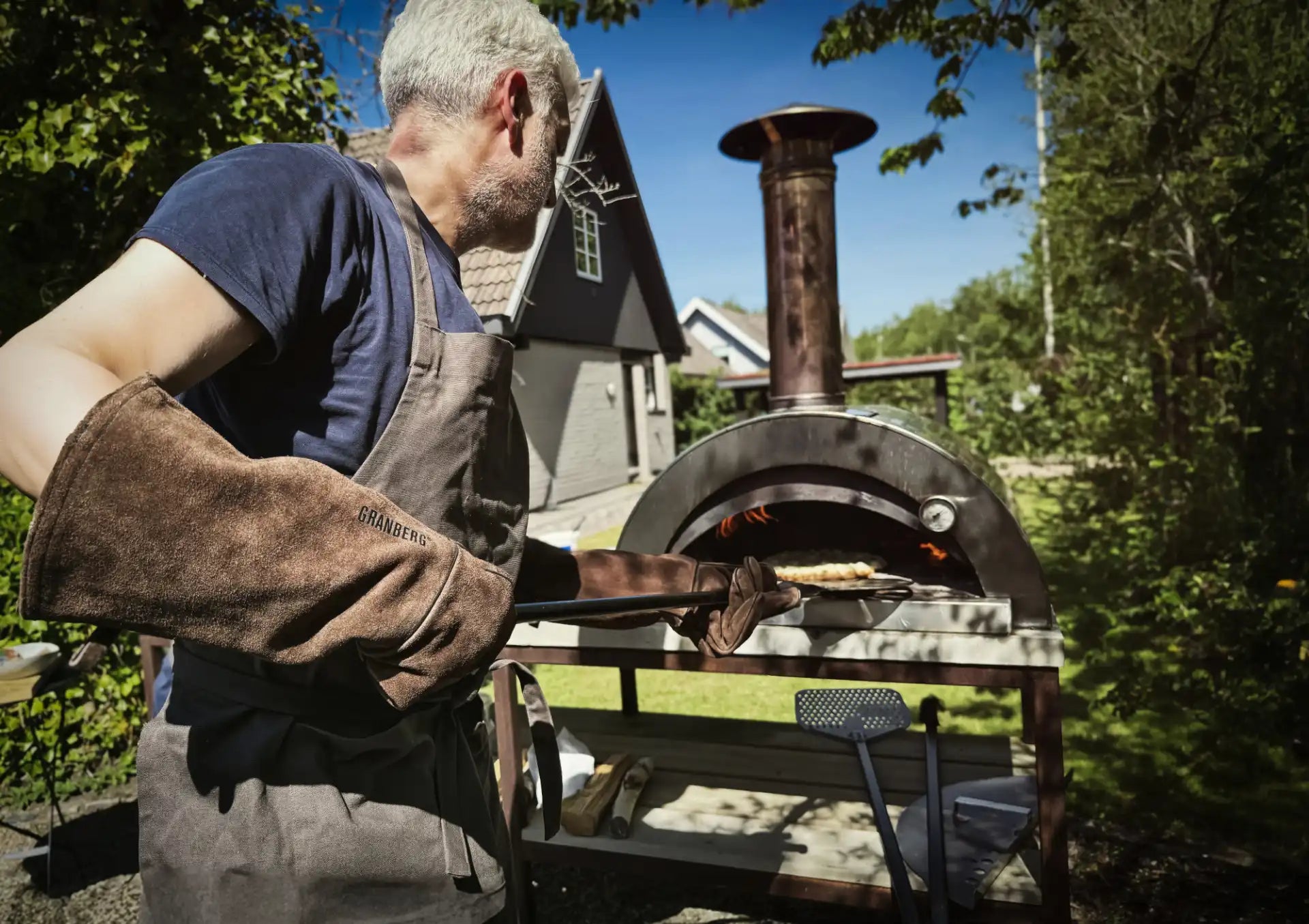 Pizzabaker bruker Granberg 1590 sveisehanske – 50 cm varmebeskyttelse for trygg håndtering av ovn og brett