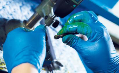 Granberg 770 blå nitril engangshansker i bruk – mekanisk arbeid med olje