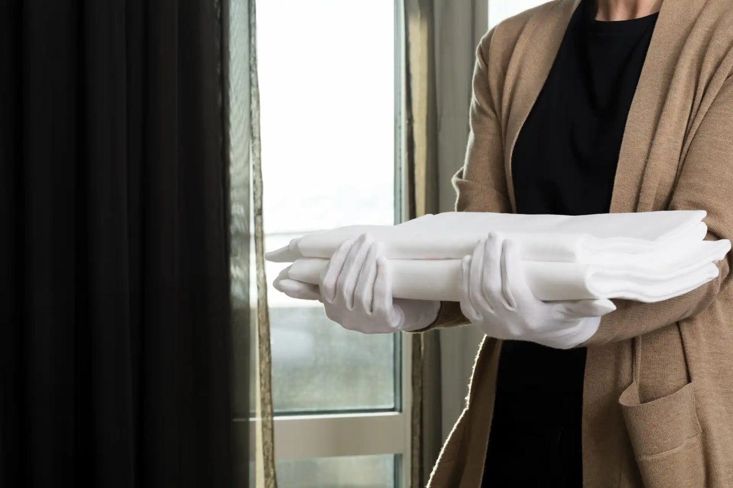 Hvite Granberg 0450 bomullshansker ved håndtering og bretting av rene tekstiler