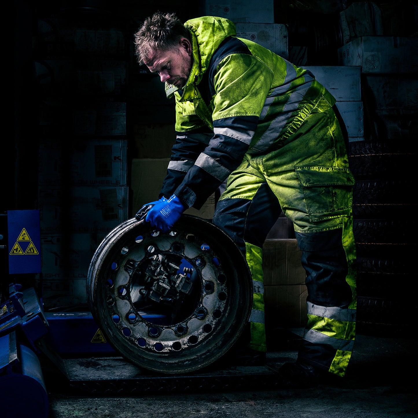 Arbeider med bilhjul iført Granberg 0490 hansker som gir sikkert grep i vått og oljete verkstedsmiljo.
