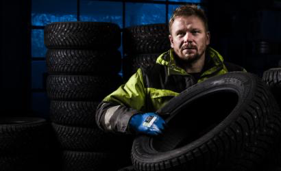 Mekaniker i dekkverksted med Granberg 0490 monteringshansker for industriell bruk