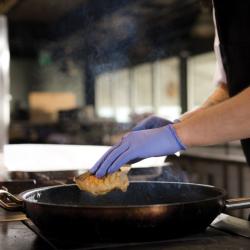 Granberg 624 indigo Soft Nitrile engangshansker i bruk på kjøkken – legger mat i stekepanne, matgodkjent