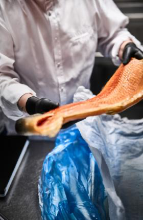 Kokk løfter laksefilet med Granberg 633 svarte nitrilhansker – Soft Nitrile, pudderfri og matgodkjent