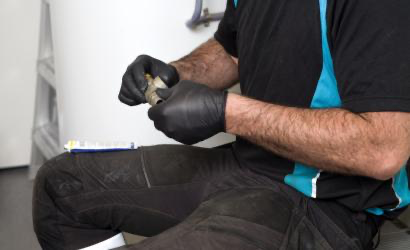 Rørlegger med Granberg 880 svarte nitrilhansker som monterer rørkobling – pudderfri hanske med godt grep