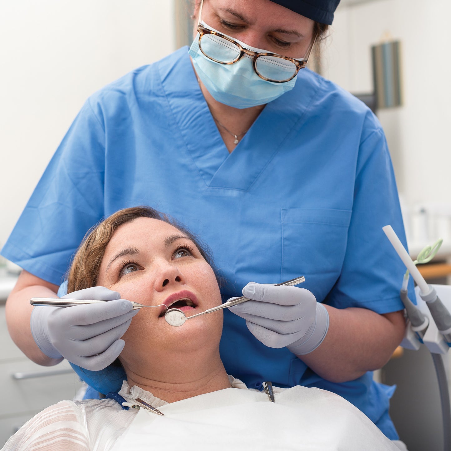 Tannlege med COATS® nitrilhansker undersøker pasient; hudvennlige, pudderfrie medisinske hansker