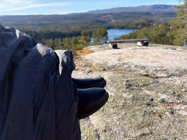 utsikt over fjell og innsjø sett fra en person sittende i utekos mikrofiber™ med føttene strukket frem